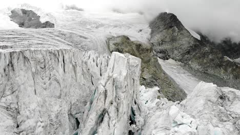 aerial flyover through the ice crevasses of the moiry glacier near grimentz in valais, switzerland with on a cloudy summer afternoon