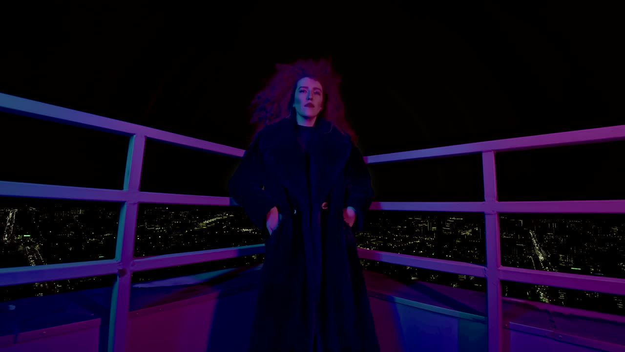 Mulher de casaco em um terraço à noite