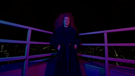 woman in a coat on a rooftop at night