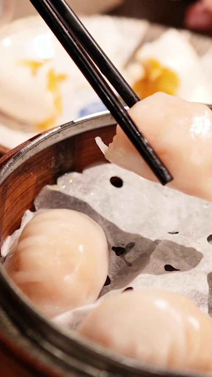 Chopsticks picking dumplings from bamboo steamer