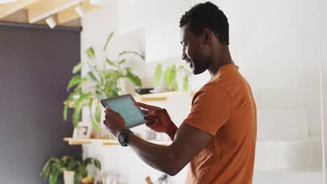 hombre afroamericano feliz usando una tableta con el pronóstico del tiempo