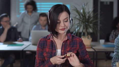 woman multitasking in office: call center agent applies makeup while working