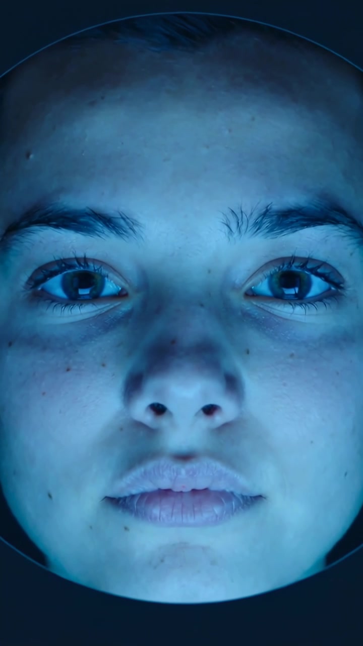 Video verticale: Registrazione, zoom della telecamera, volto di ragazza adolescente che mostra lentiggini sotto una luce ad anello blu