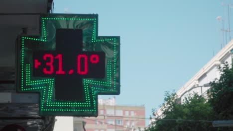 led pharmacy cross temperature display in celcius on summer morning