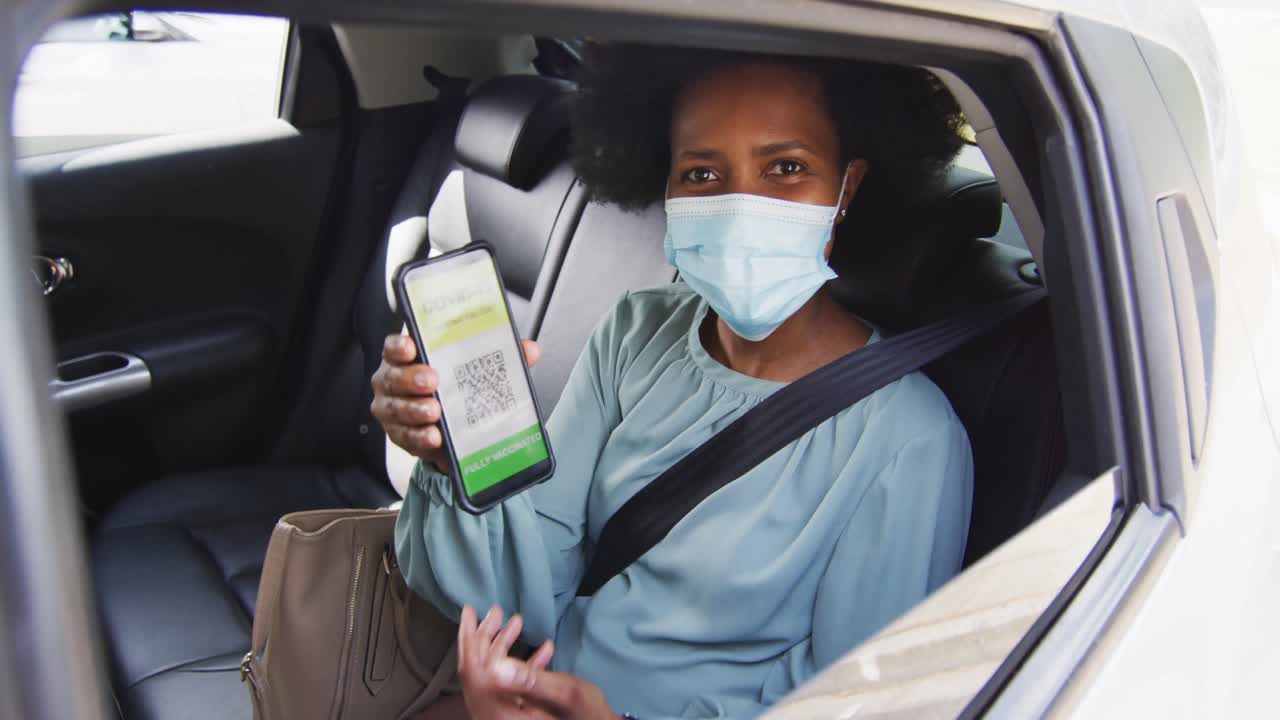 retrato de una mujer de negocios afroamericana con máscara facial con certificación de covid-19 en un teléfono inteligente