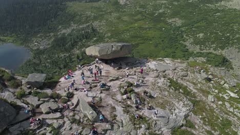 aerial view of a large rock formation with people hiking in the mountains