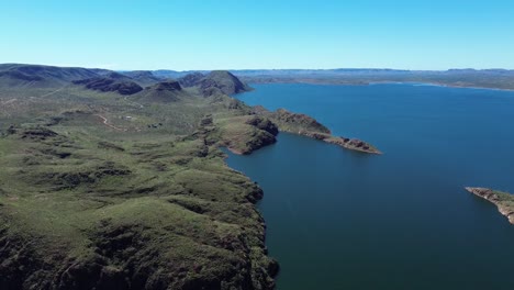 cinematic aerial shot of lake argyle in western australia, revealing the calm water, rocky landscape and remote natural beauty.