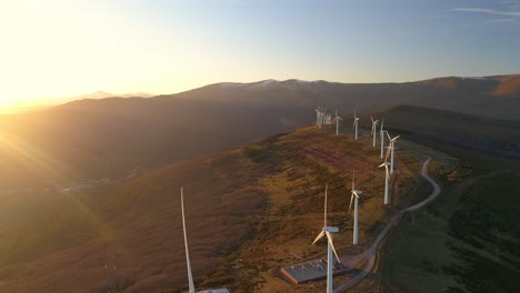 aerial view of wind turbines on a mountain at sunset