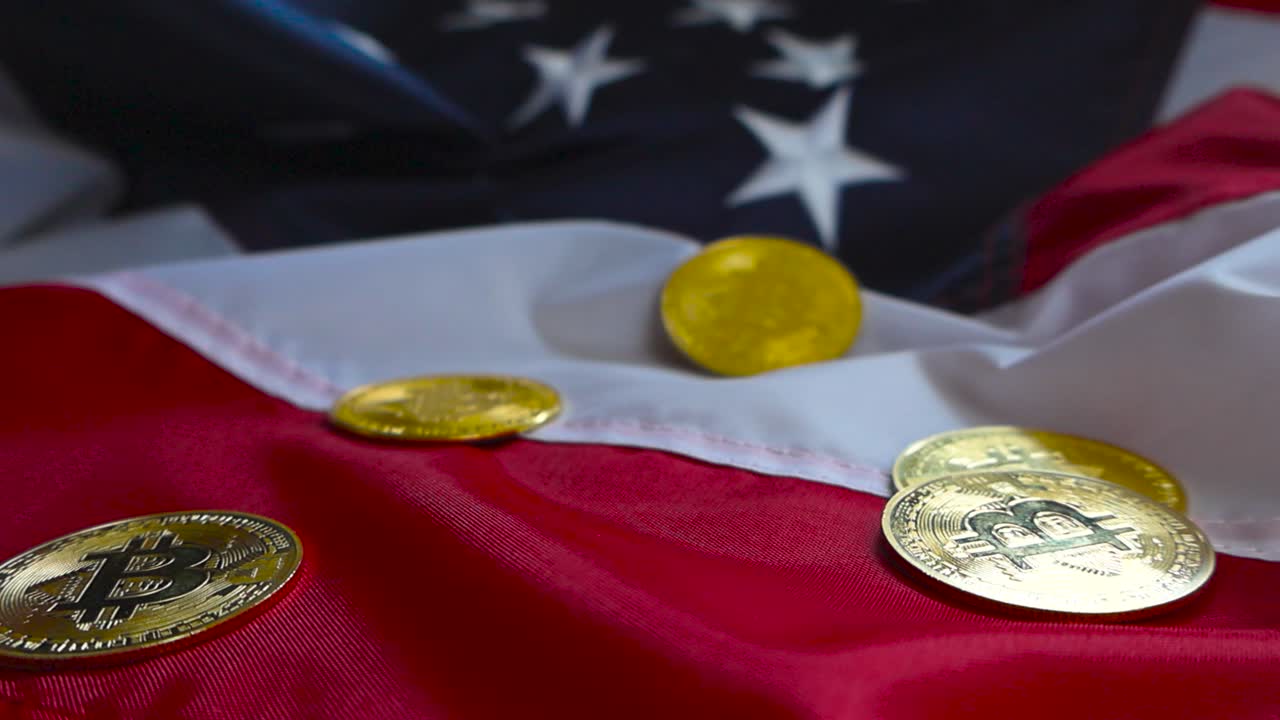 Gorgeous cinematic footage of golden shiny Bitcoin cryptocurrency money coins on a United states flag under good lights. The coins are reflective and made of gold or metal.