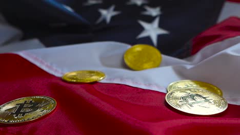 gorgeous cinematic footage of golden shiny bitcoin cryptocurrency money coins on a united states flag under good lights. the coins are reflective and made of gold or metal.