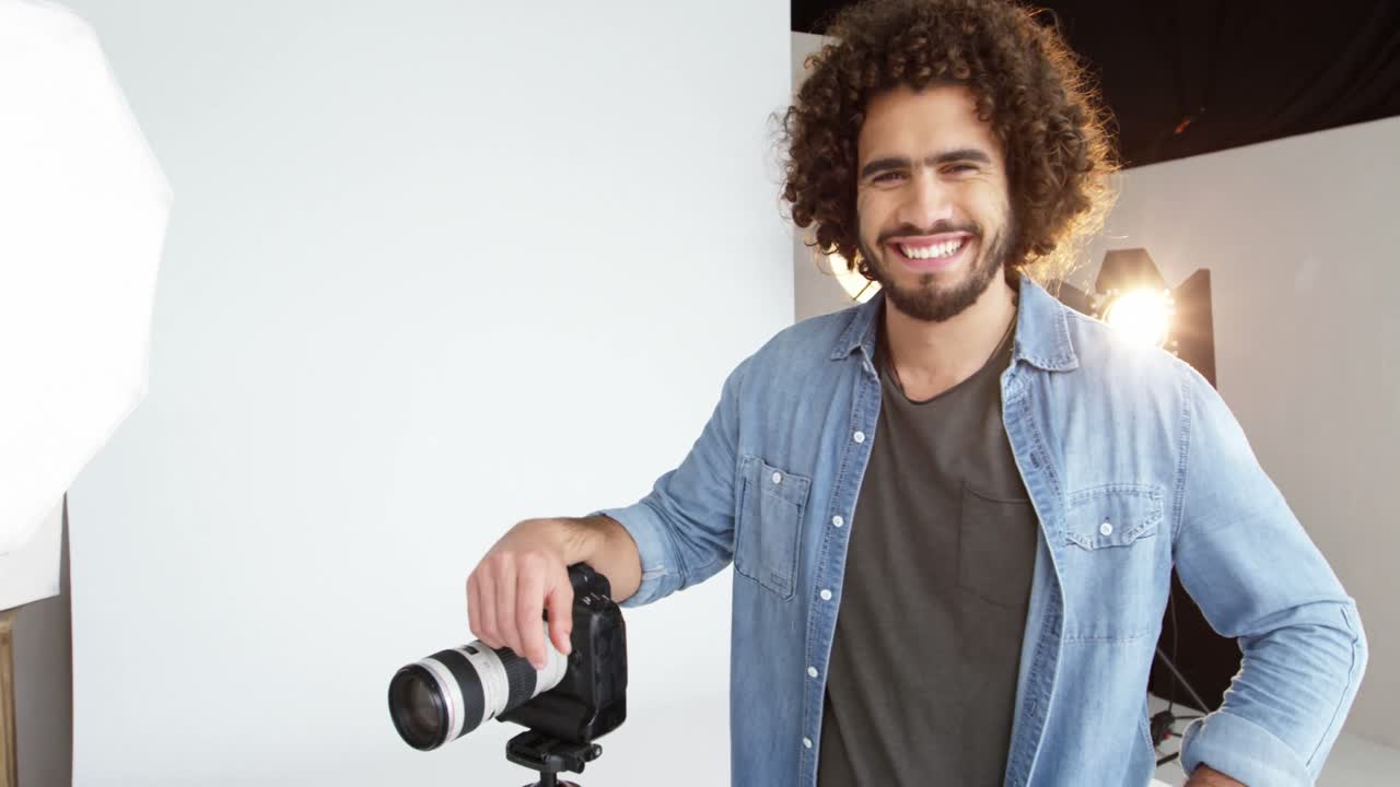 Fotógrafo de pé com câmera digital em estúdio