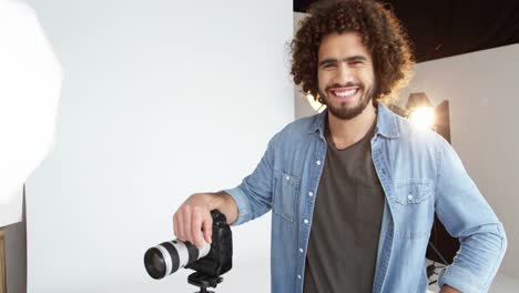 Photographer-standing-with-digital-camera-in-studio