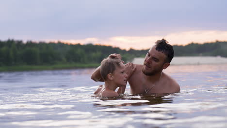 father and son swimming in the lake