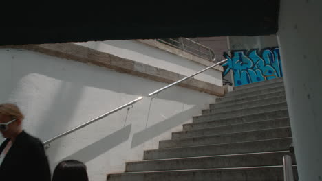 a young woman is descending into an underground pedestrian passage