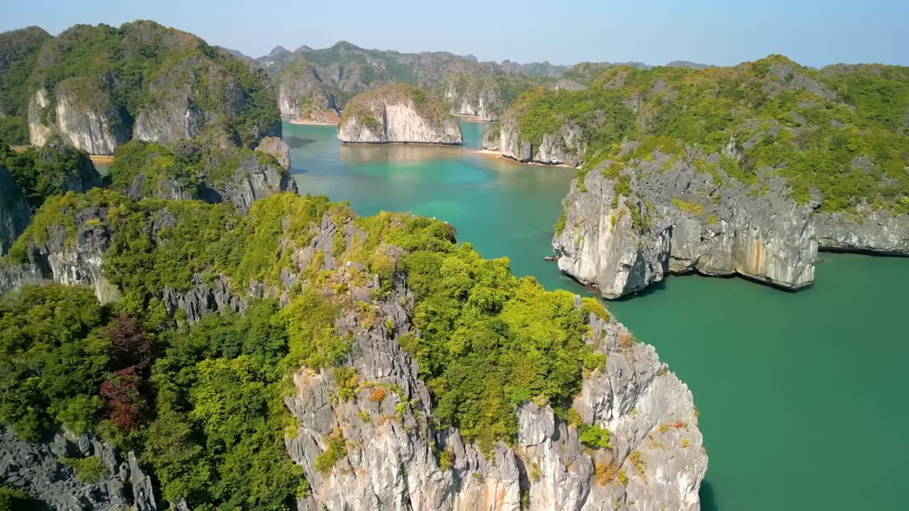 Aerial shot of Bay showcases jagged limestone peaks wrapped in greenery, with crystal-clear waters flowing through narrow passages and secluded, peaceful inlets.