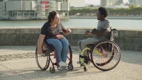 cheerful friends using wheelchairs dancing at quayside