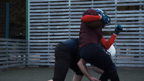 american football players engaged in a tackle on a field
