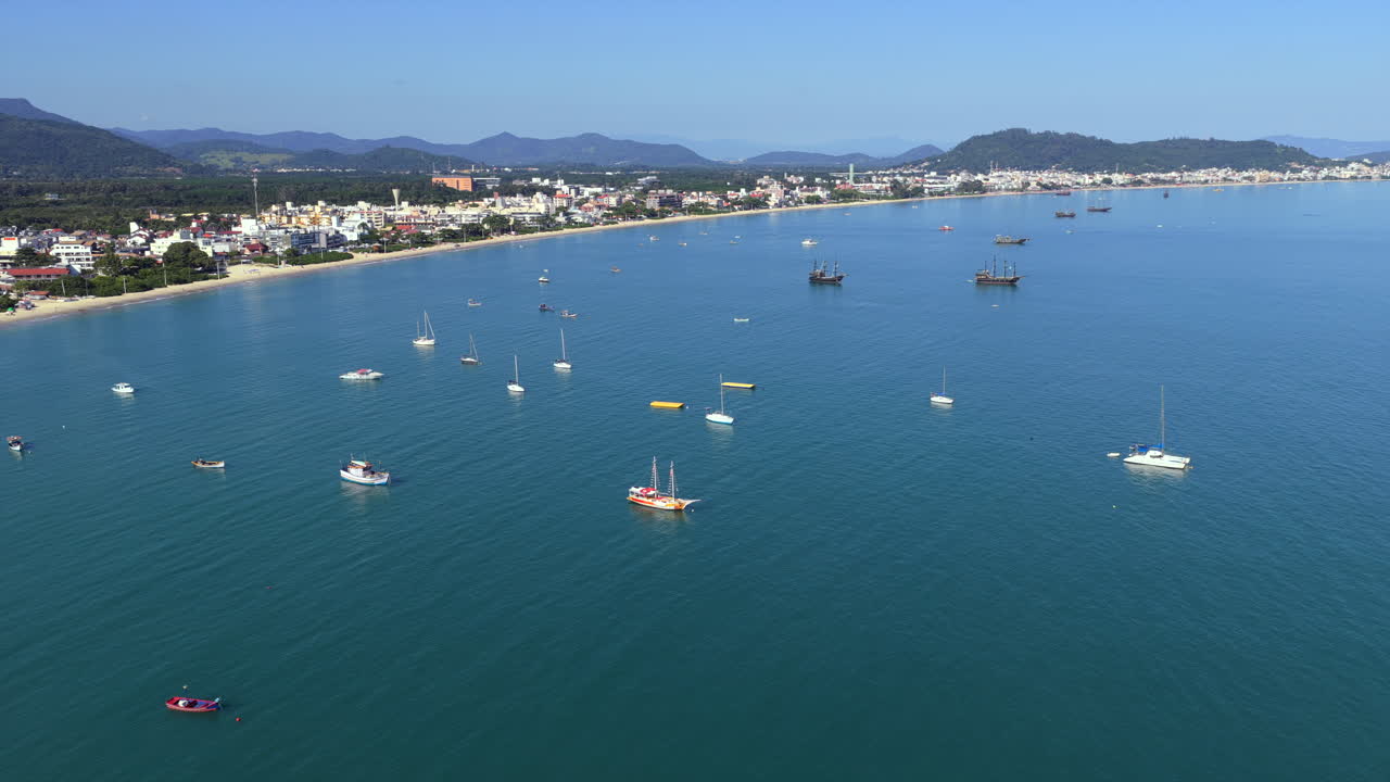 Pemandangan udara perahu-perahu yang berlabuh di dekat pantai Cachoeira do Bom Jesus di Florianopolis, Brasil, pemandangan pesisir yang tenang.