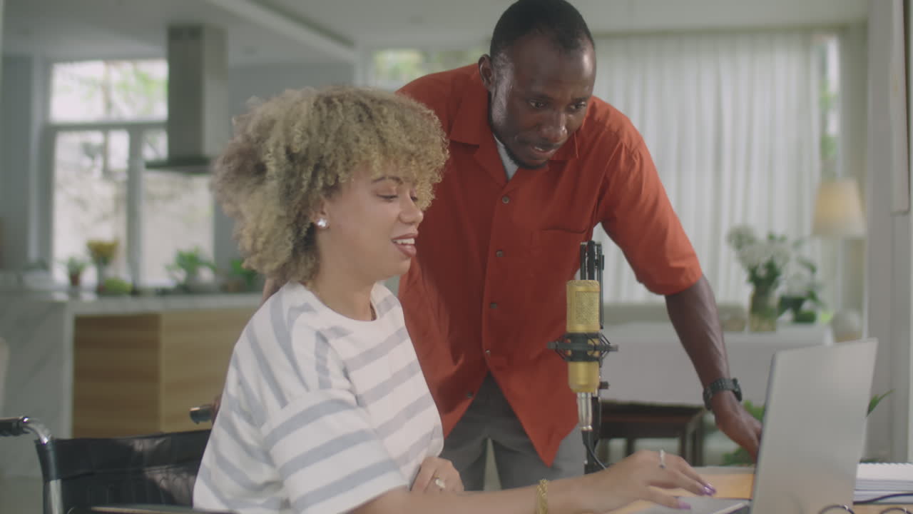 Girl in Wheelchair Speaking with Friend at Home Recording Studio