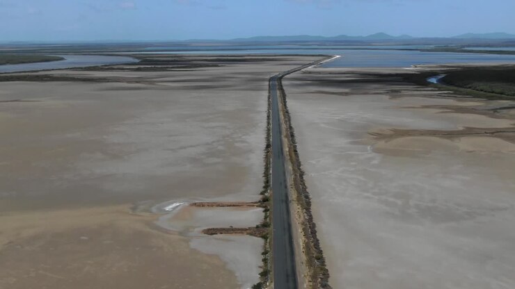 Rectilinear deserted road across wild flat territory of Casuarina island in Queensland, Australia