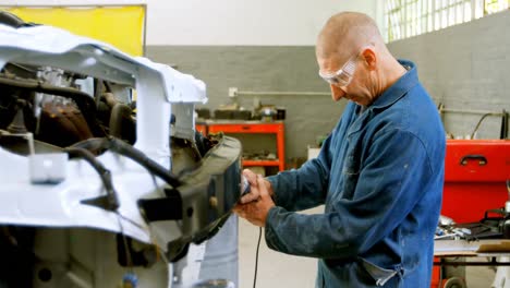 mechanic using grinding machine on a car 4k