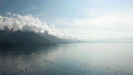 Atemberaubende-Ruhe-Auf-Dem-Ruhigen-Wasser-Des-Atitlan-Sees-In-Guatemala,-Während-Sich-Wolken-Am-Berggipfel-Sammeln