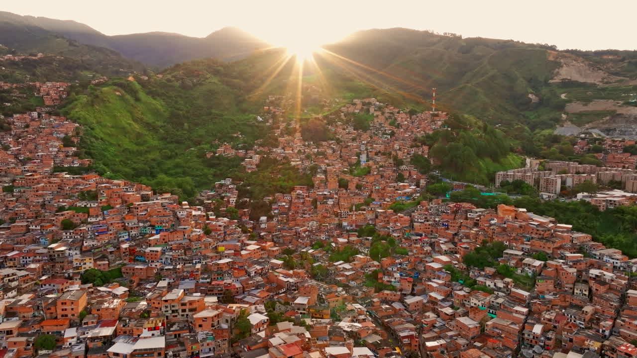 Vista con drone di Medellin, Colombia, al tramonto, che cattura un vasto panorama cittadino con luce calda, ombre profonde e cime circostanti.