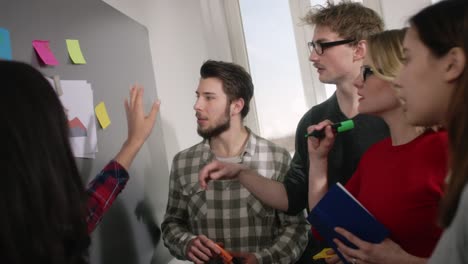 a group of concentrated students working on a pinboard with notes to describe the meaning of statistics homework