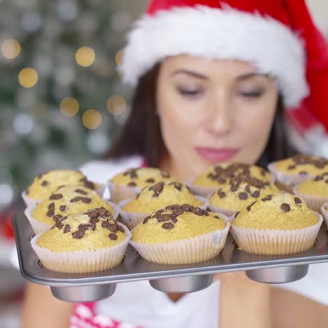 Mujer-Joven-Con-Una-Bandeja-De-Cupcakes-Navideños