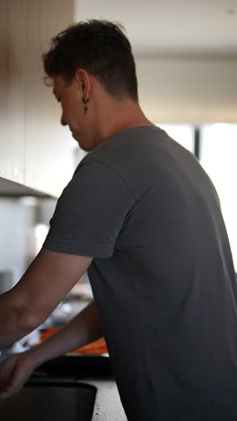 hombre cocinando zanahorias en la cocina