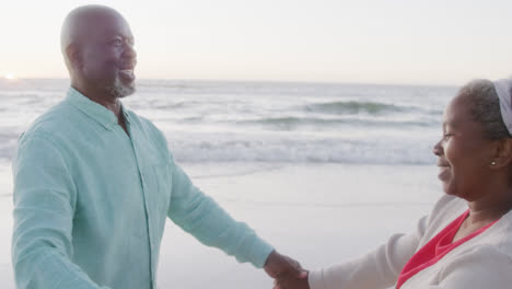 Feliz-Pareja-Afroamericana-Mayor-Bailando-En-La-Playa,-En-Cámara-Lenta