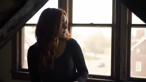 a pensive moment: capturing the essence of reflection and longing through a female figure in a dimly lit room adjacent to a window