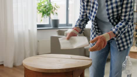 Mujer-Desengrasando-La-Superficie-De-Una-Mesa-Vieja-Con-Disolvente.-Concepto-De-Renovación,-Bricolaje-Y-Mejora-Del-Hogar.-Mujer-Desengrasando-La-Superficie-De-Una-Mesa-Vieja-De-Madera-Redonda-Con-Disolvente-Y-Papel.