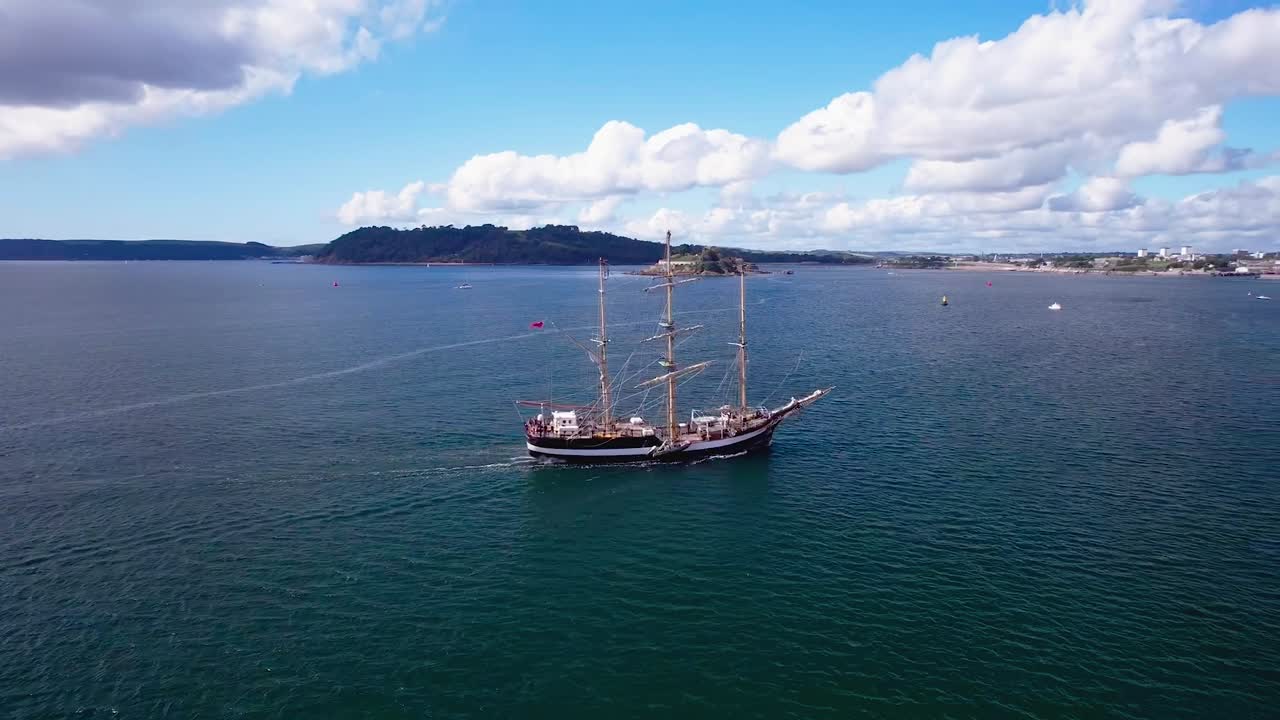 hermoso barco navegando hacia plymouth con un disparo de drone orbital aéreo