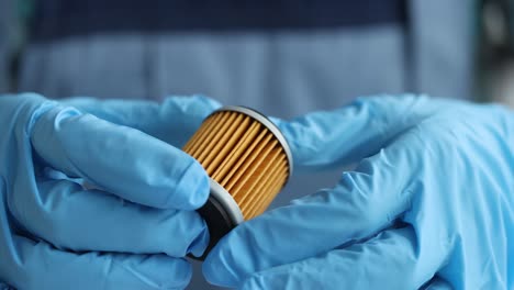 filtro de aceite o combustible del coche en manos de un mecánico de automóviles de primer plano
