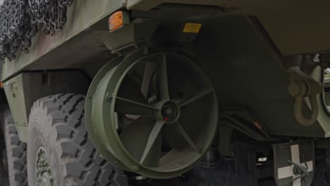 Propeller-of-amphibious-military-vehicle-with-massive-wheels,-close-up-view