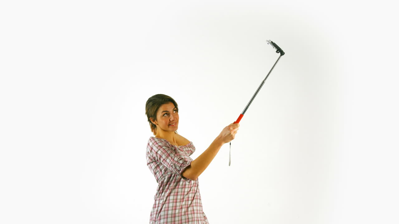 una chica bonita tomando una selfie con un palo