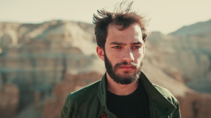 Uomo in piedi nel deserto che affronta una delusione amorosa dopo una rottura, primo piano.