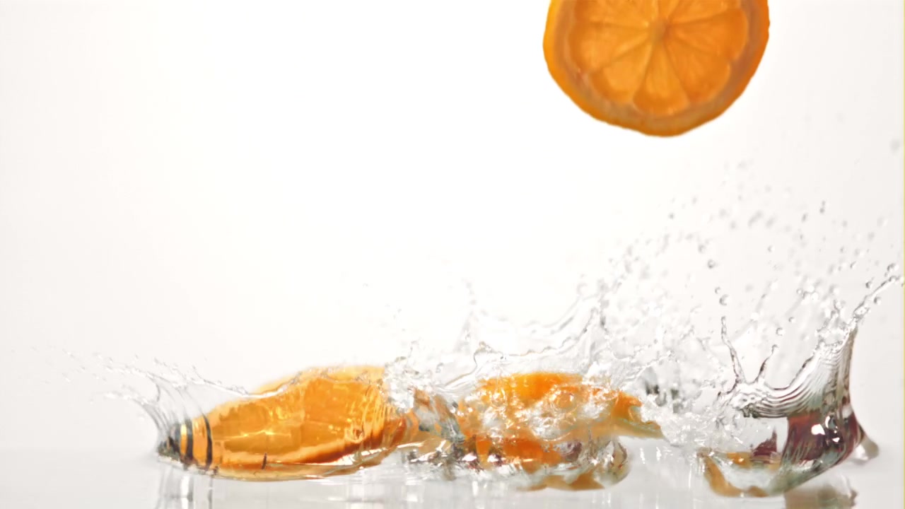 Fette d'arancia che si tuffano nell'acqua in super slow motion
