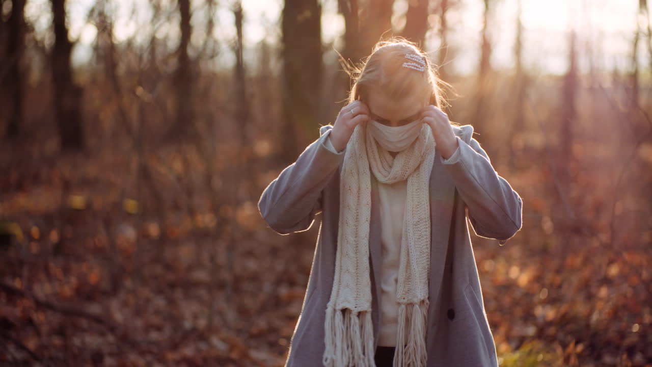 женщина снимает защитную маску и дышит свежим воздухом в лесу