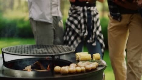 hombre poniendo maíz en la parrilla