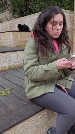 young adult woman using smartphone outdoors