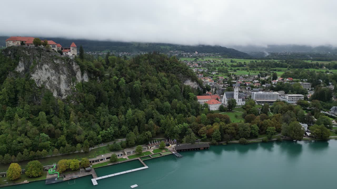 Castello di Bled, Slovenia, vista aerea con drone, ripresa panoramica di nuvole basse sulle montagne distanti.