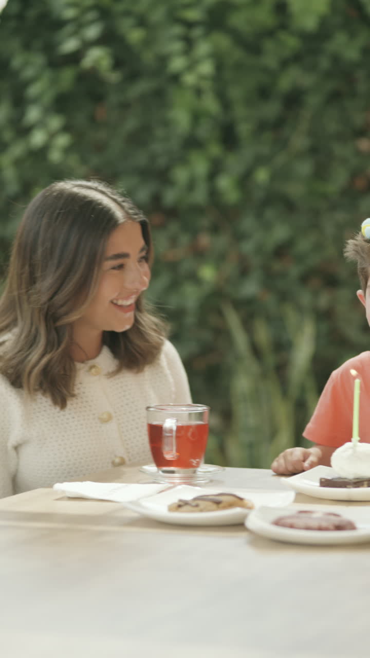 Wide shot clip with panning showing a boy celebrating his birthday with his family.