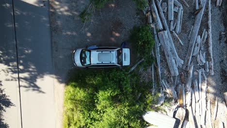 mini furgoneta plateada con baúl abierto estacionado justo en una playa rocosa en el noroeste del pacífico