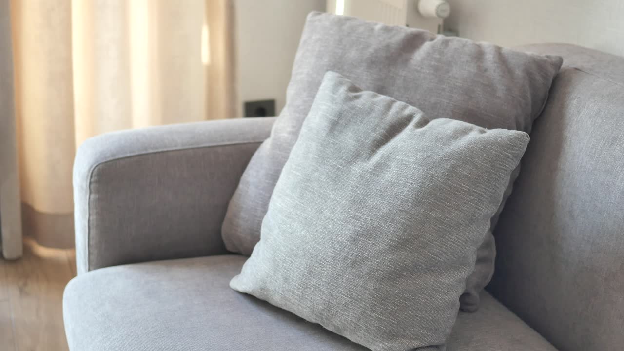 sofá gris con almohadas