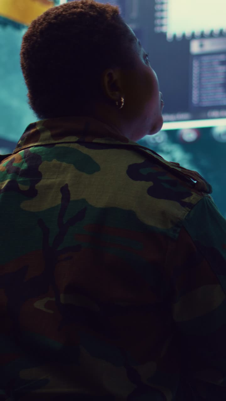 Military Person in Camouflage Monitoring Data in a High-Tech Control Room