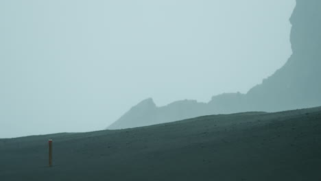 rain and wind streak past a trail marker post in capelinhos, faial, azores