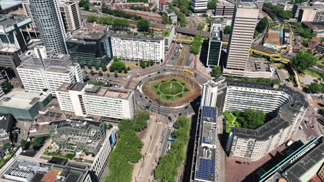 the drone is rotating around a big and busy roundabout in the middle of the city centre of rotterdam the netherlands aerial footage 4k