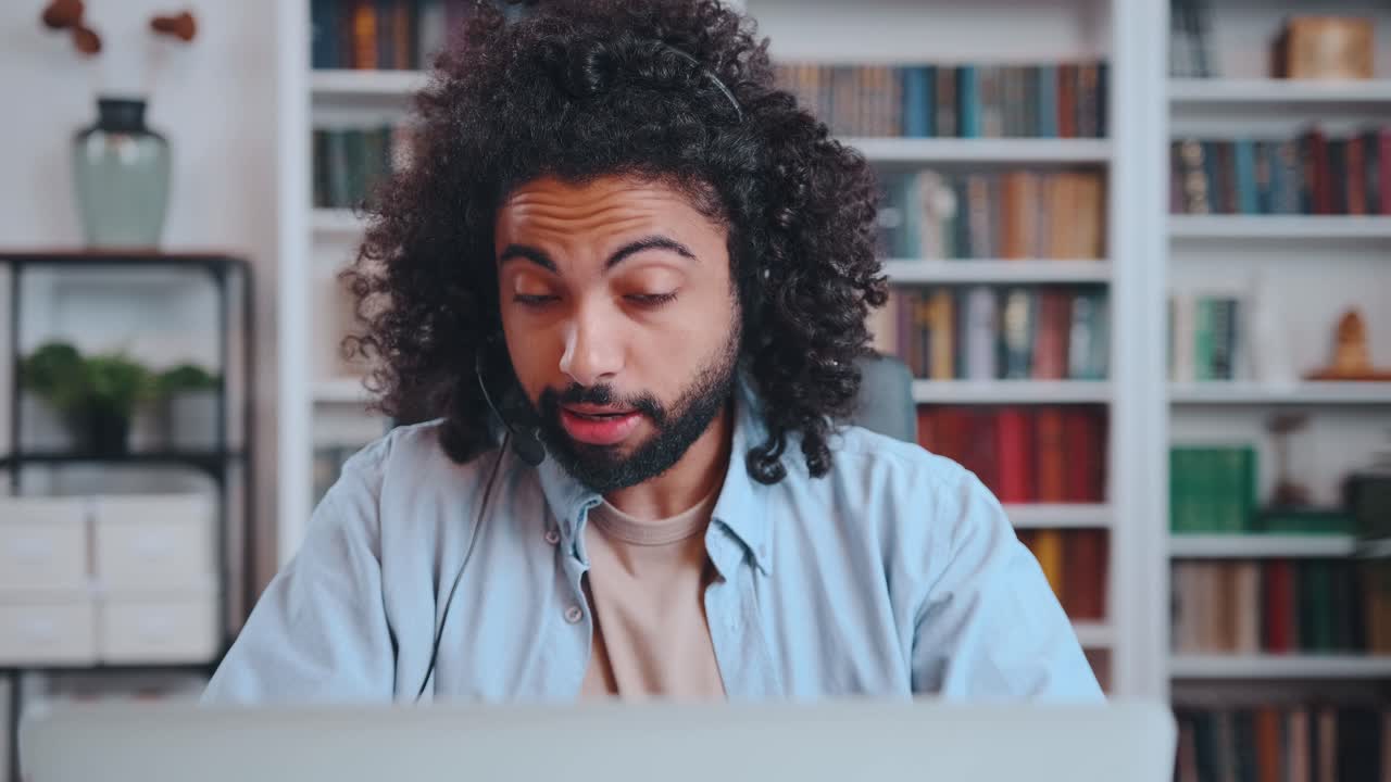 African american man talks video call using headset with microphone via laptop